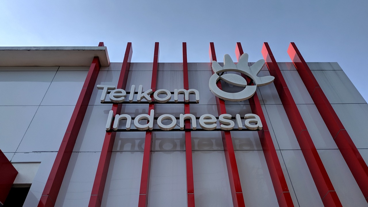 Pemandangan malam hari gedung Telkom Indonesia yang terang benderang, simbolisasi dari komitmen perusahaan untuk selalu menyediakan layanan dan konektivitas tanpa henti