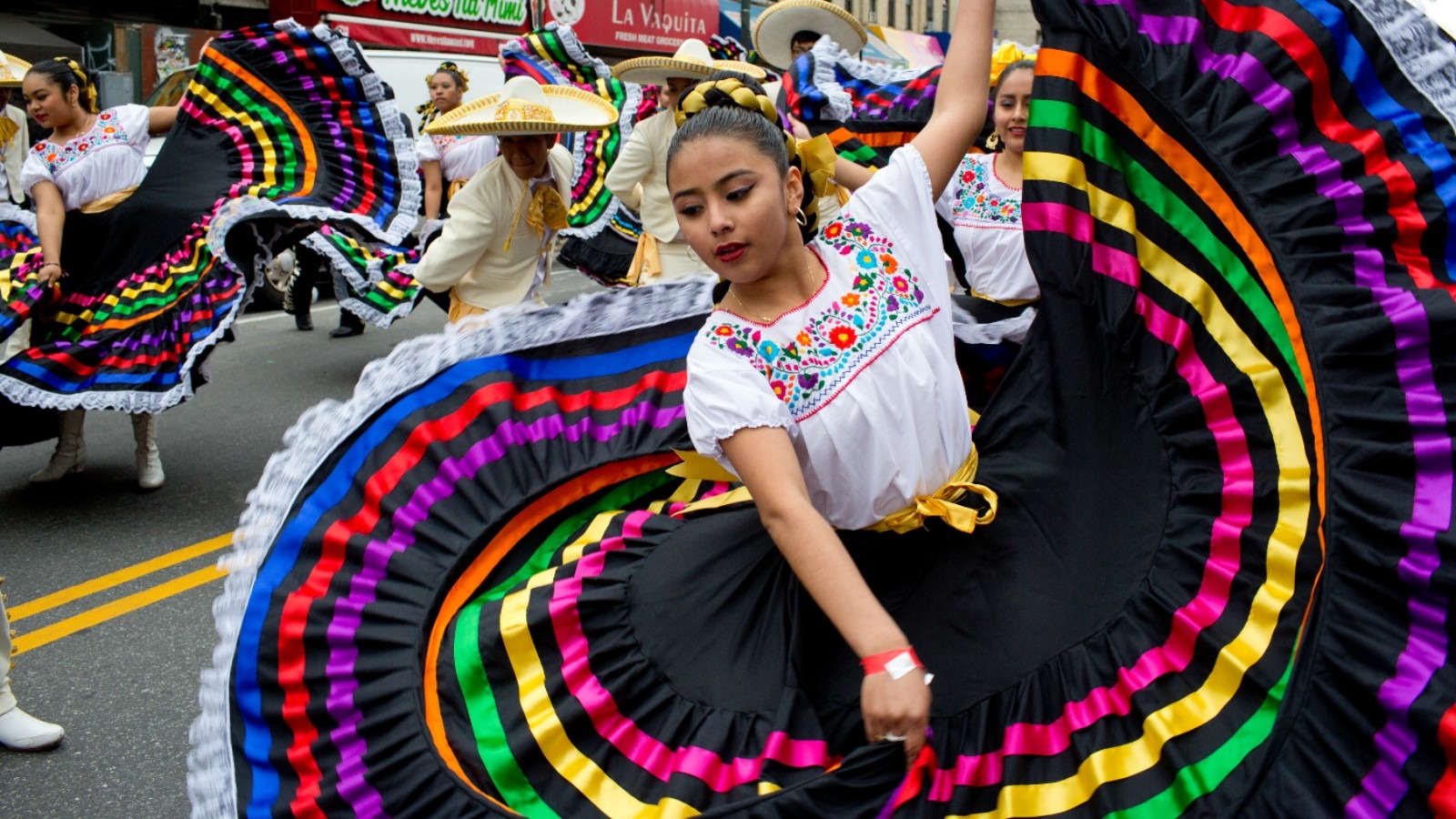 A Cinco de Mayo parade float adorned with Mexican cultural motifs and banners representing historical landmarks.
