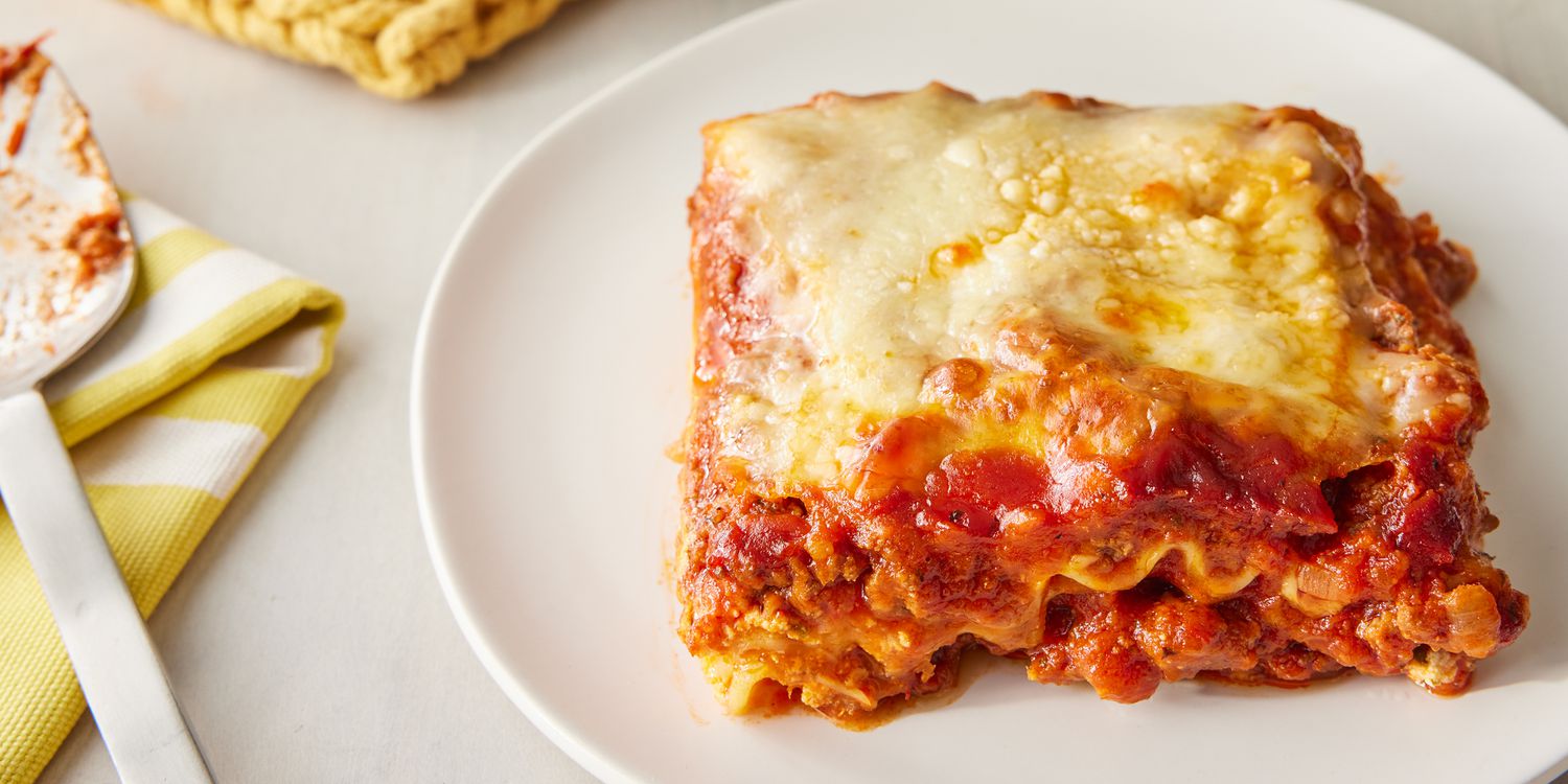 A mouth-watering slice of lasagna showcasing layers of pasta, rich meat sauce, and melted cheese, garnished with fresh basil